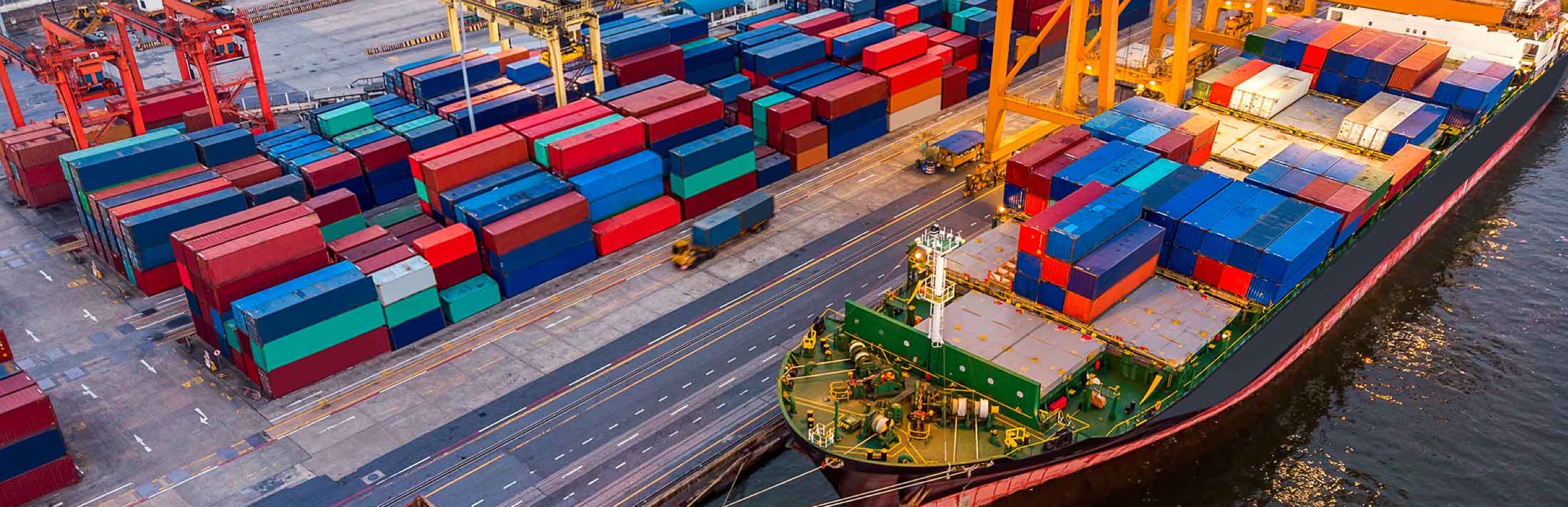 Ship at dock next to unloaded cargo.