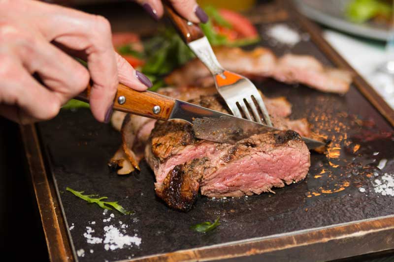 person cutting beef
