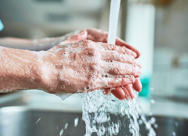 Soapy hands under warm running water