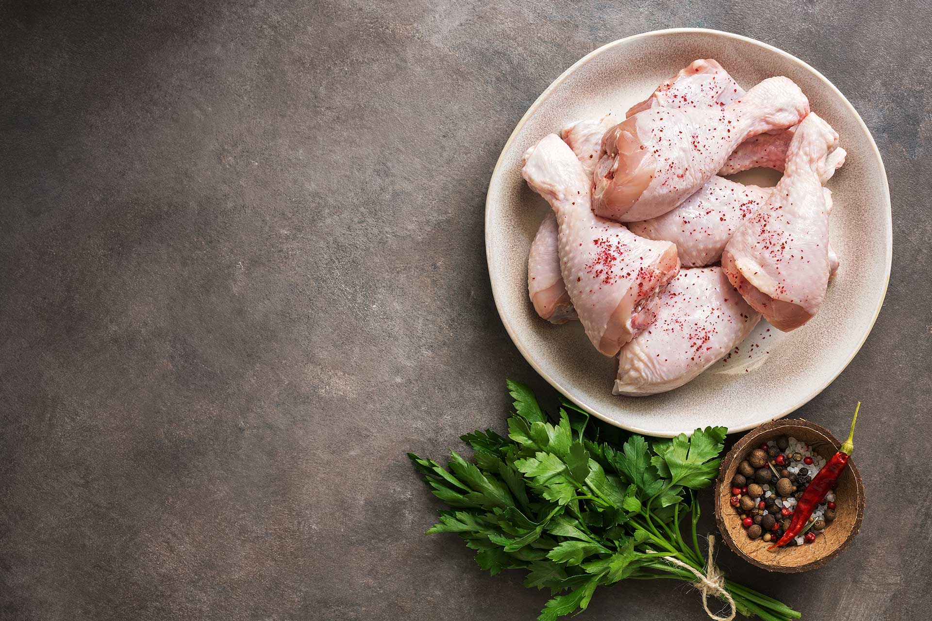 Raw chicken on plate with ingredients laying near.