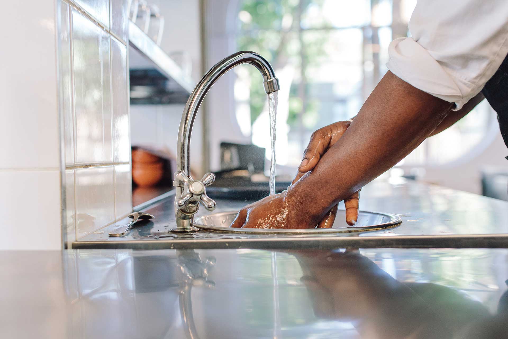 Person washing hands in a sink.