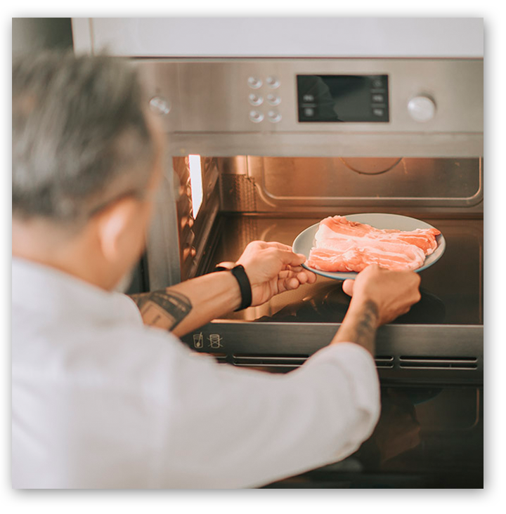 Man defrosting meat in microwave
