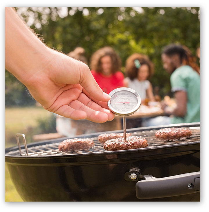 Checking grilled burgers with a food thermometer