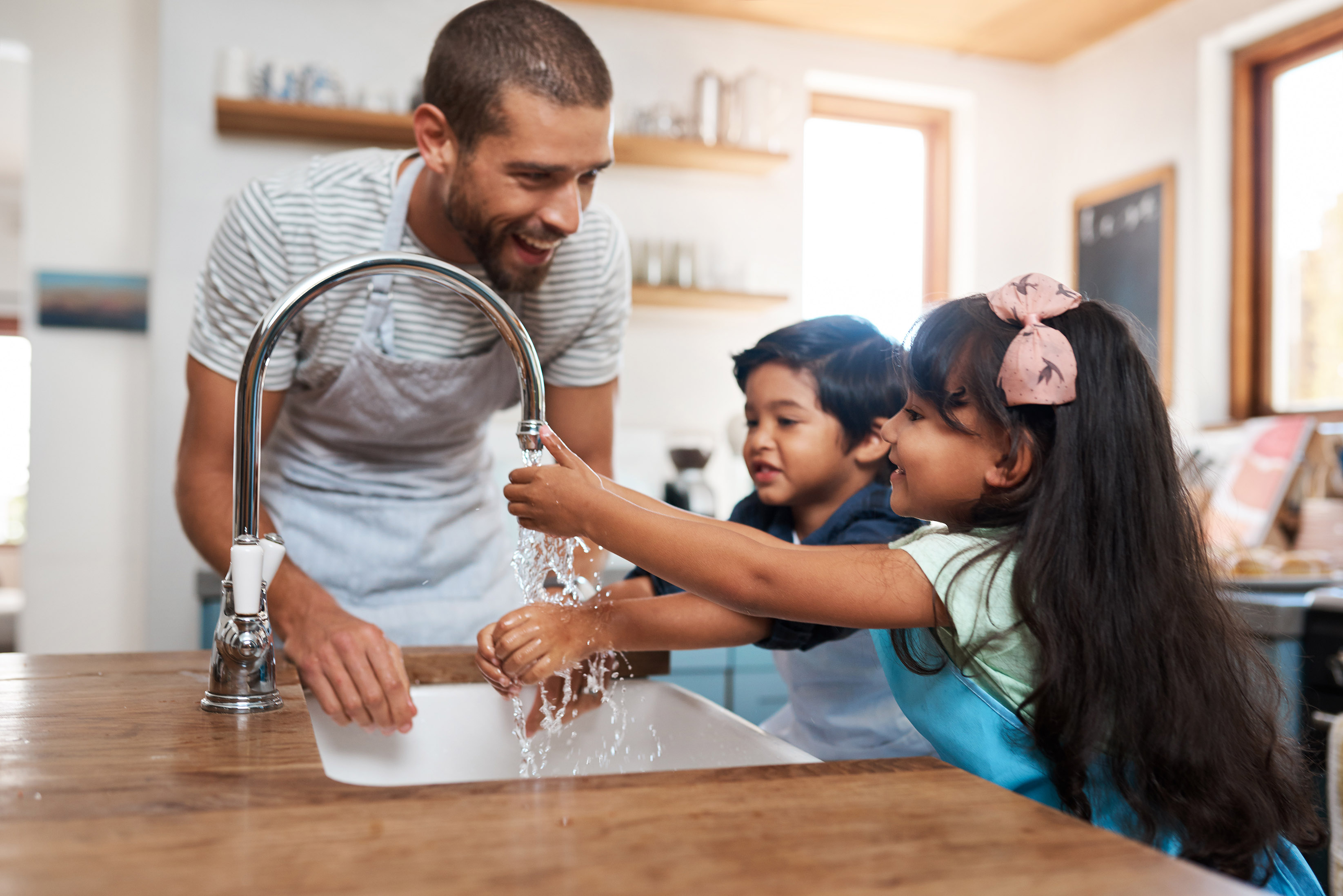 Man helping kids wash their hands