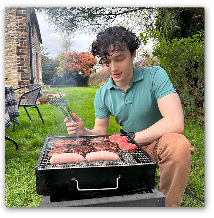 Young man grilling burgers